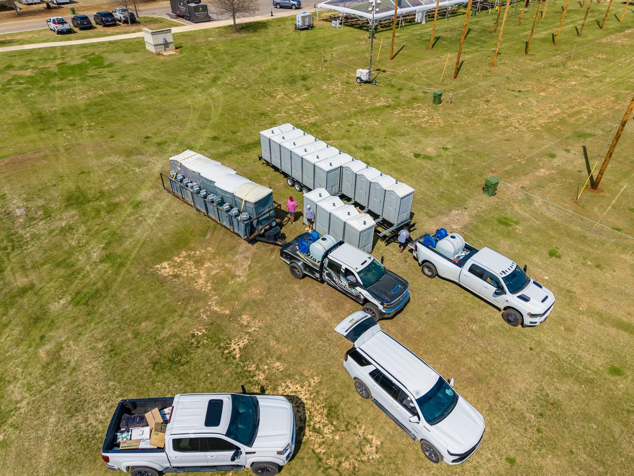 McMichael Waste Services crew staging restroom trailers and portable toilets at an outdoor event in Huntsville, Alabama