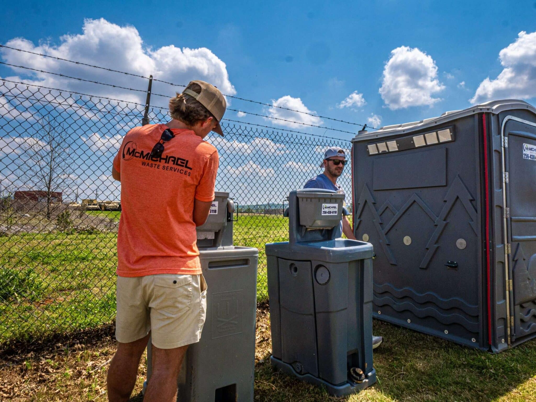 McMichael Waste Services crew member servicing a portable hand-washing station on site in Alabama