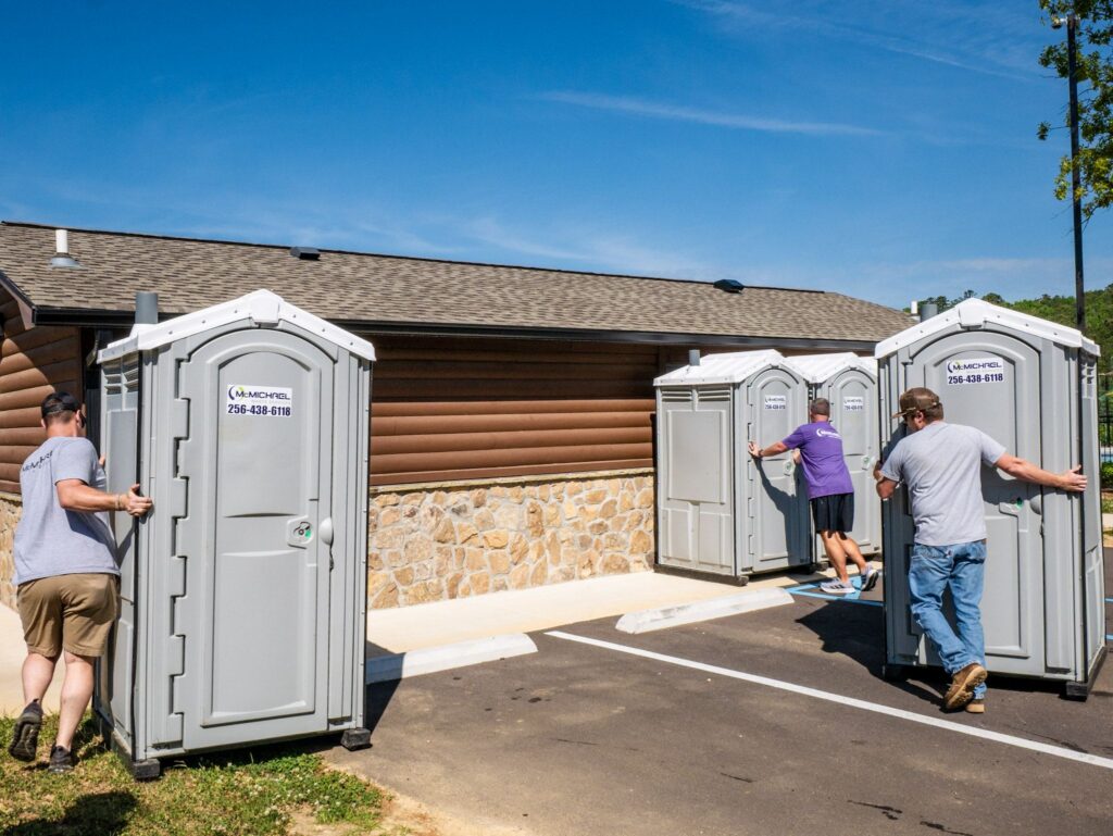 McMichael Waste Services crew unloading portable toilets from the delivery truck at an Alabama event