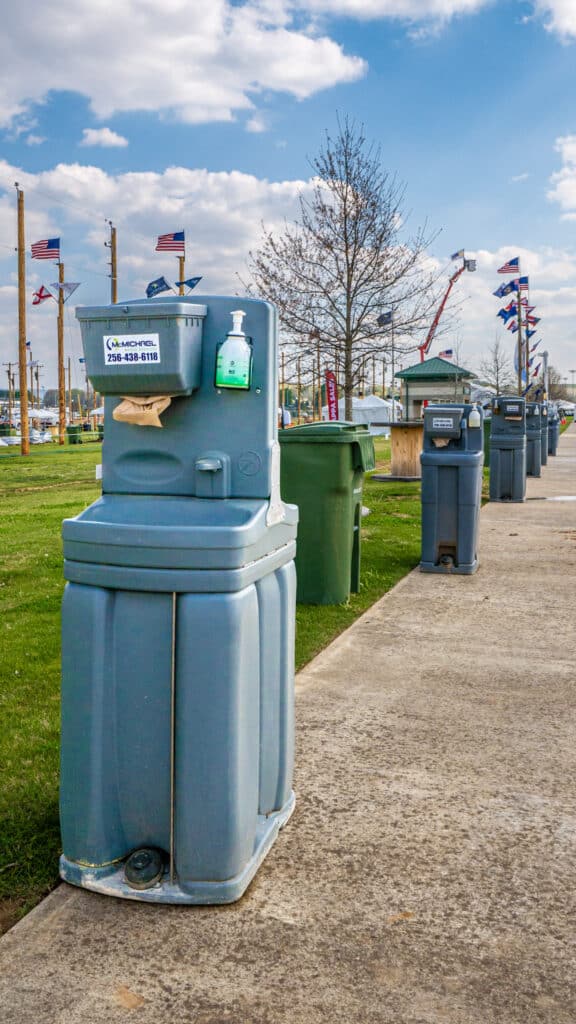 McMichael Waste Services hand-wash stations lining the walkway at an outdoor event in Huntsville, Alabama