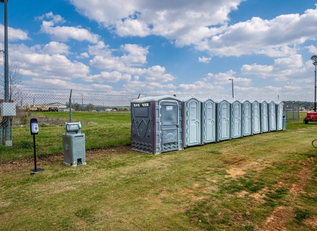 Row of McMichael Waste Services portable toilets with a hand-wash station in Huntsville, Alabama