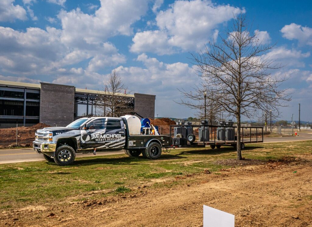 McMichael Waste Services wrapped service truck on a jobsite in Huntsville, Alabama