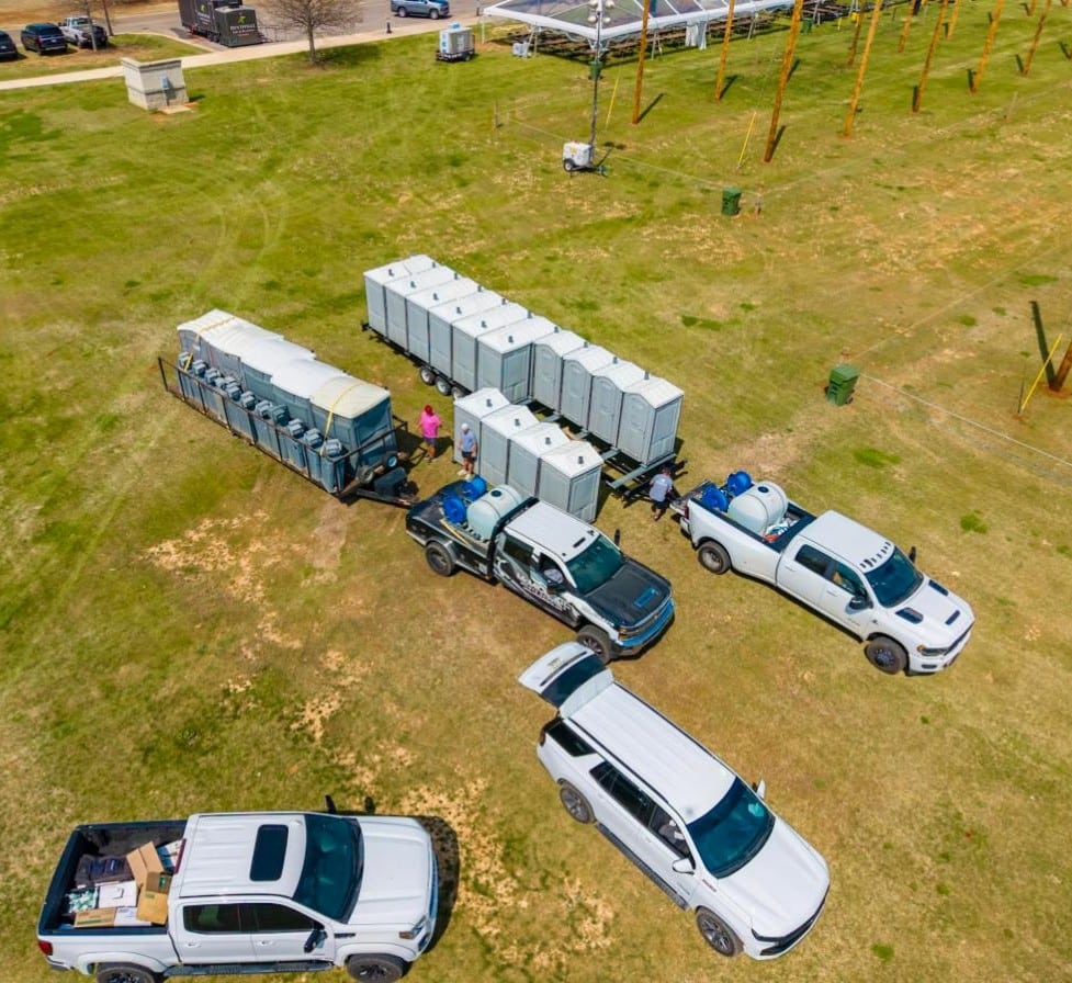 McMichael Waste Services crew setting up portable toilets and trailers at an Alabama event ground