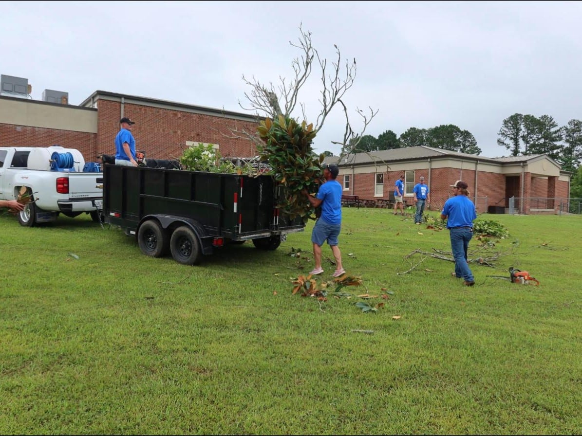 McMichael Waste Services crew loading debris into a 10-yard dump trailer in Alabama