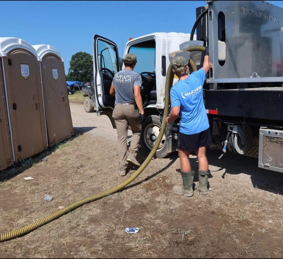 McMichael Waste Services crew servicing portable toilets with a vacuum truck at an Alabama event