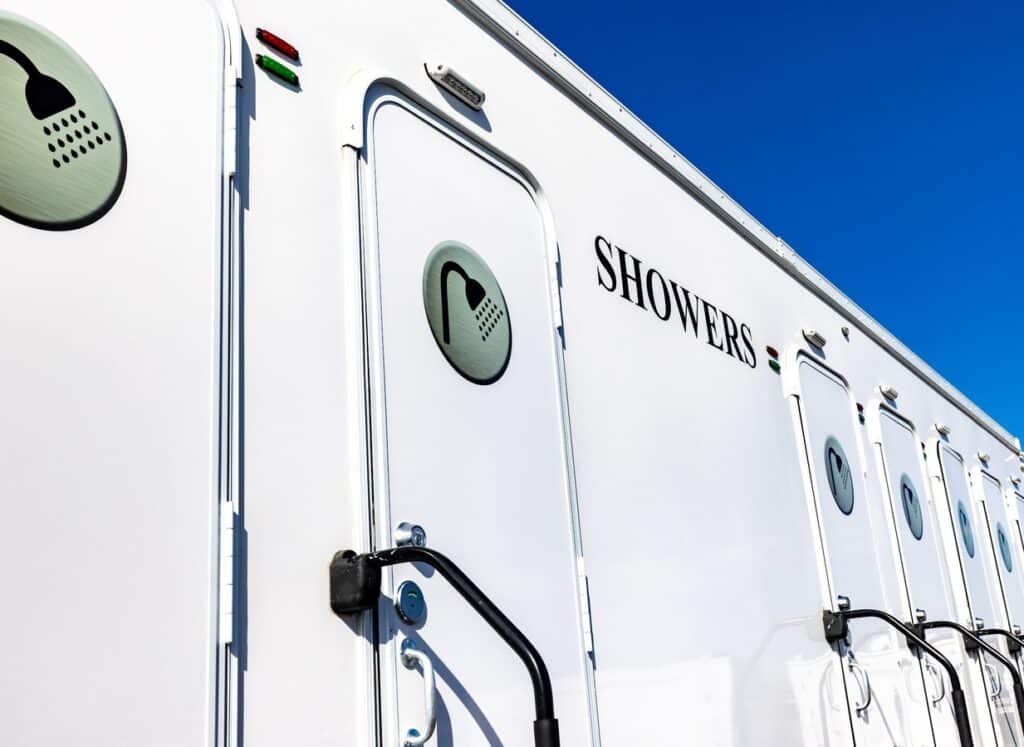 Shower trailer stall door with a shower icon and grab handle