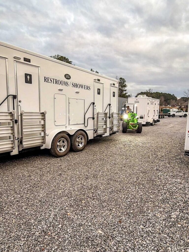 Restroom and shower combination trailers lined up on a gravel lot